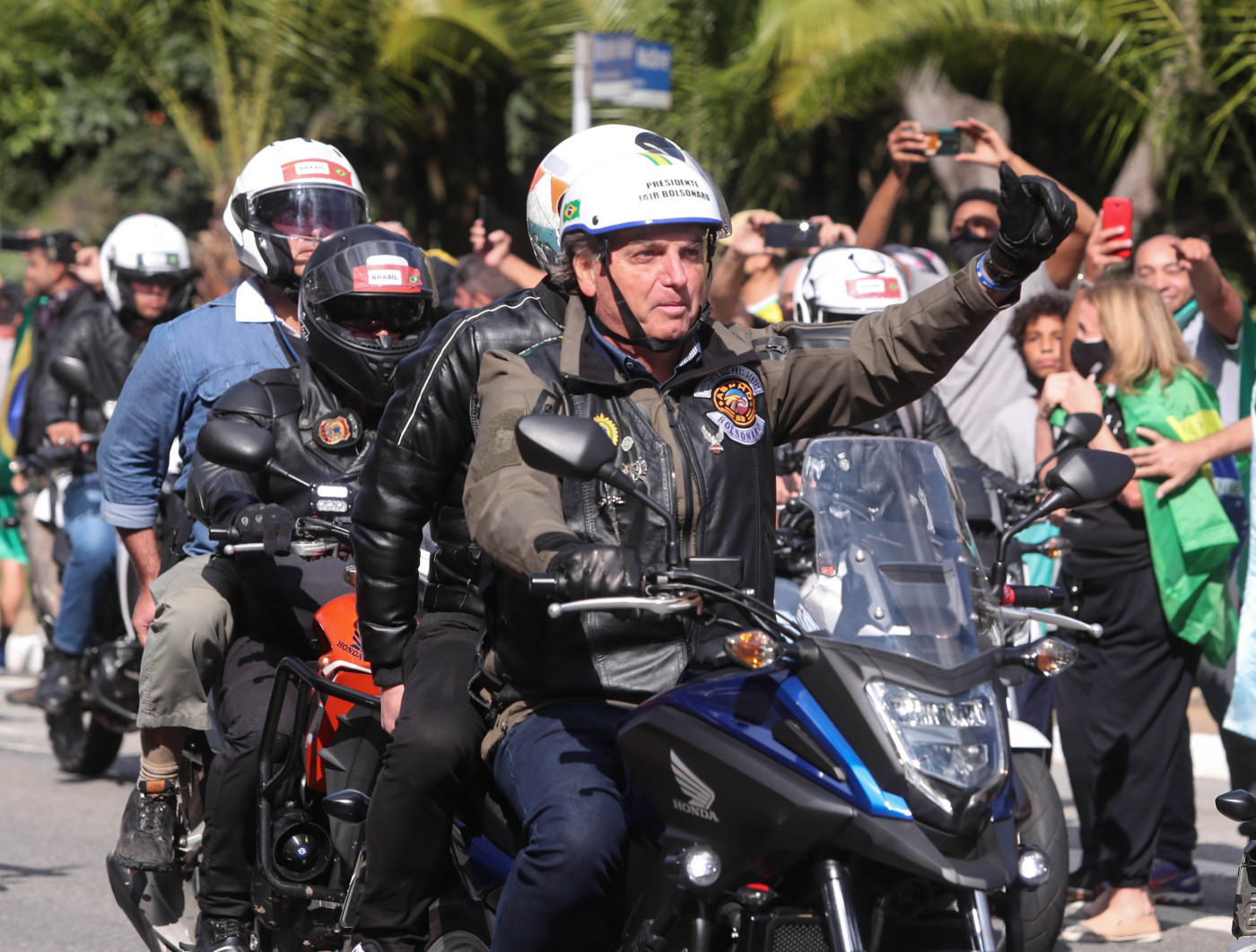 Jair Bolsonaro em moto acenando a apoiadores