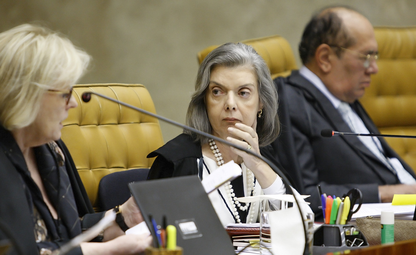 Ministra Cármen Lúcia séria, observando a ministra Rosa Weber em sessão do STF