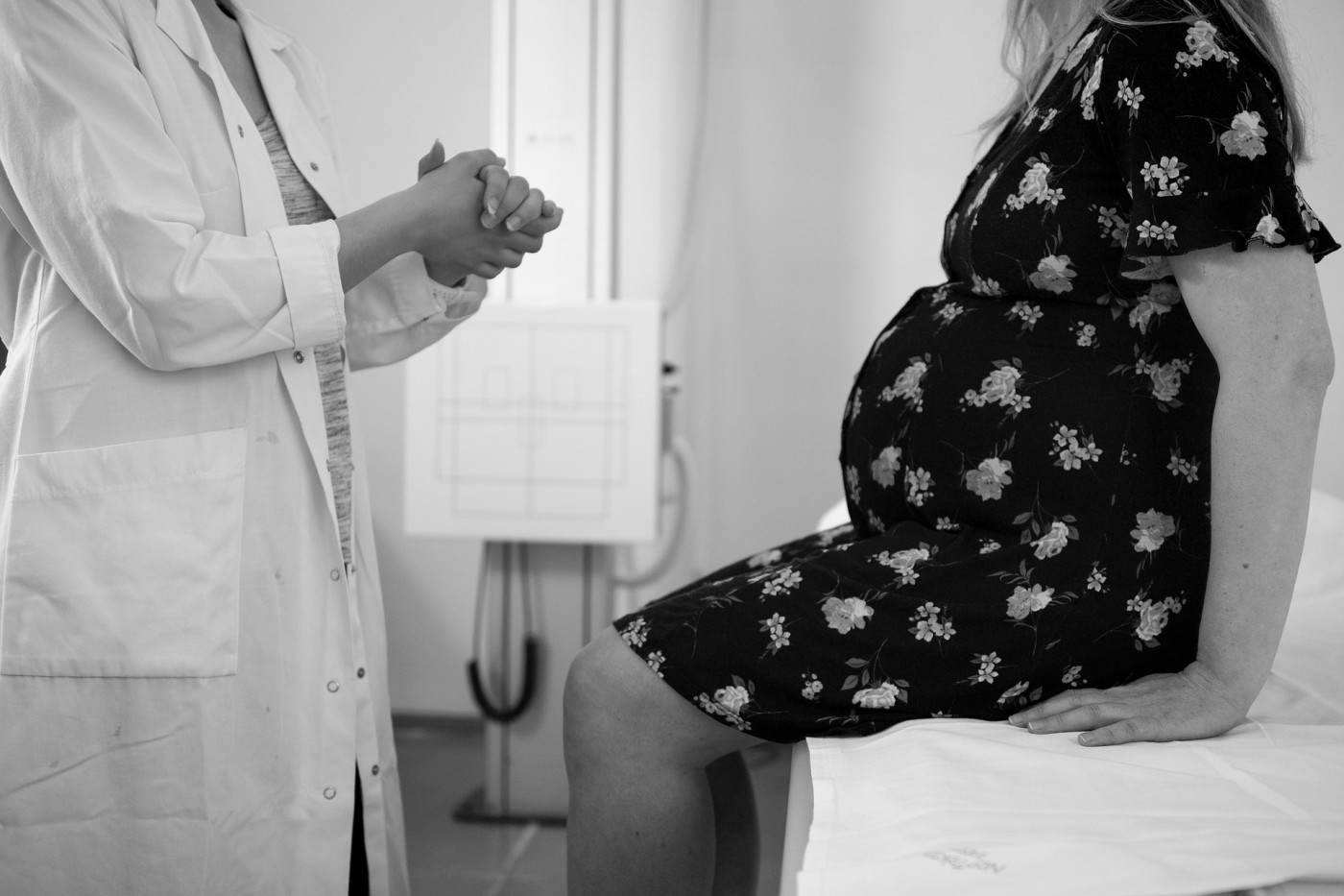 Médico conversa com paciente grávida em consultório