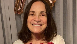 Regina Duarte sorrindo com rosas na mão