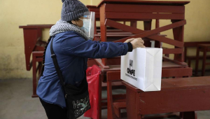 pessoa colocando voto em urna