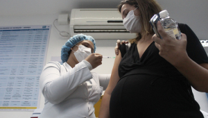 Profissional da saúde aplica vacina em mulher grávida