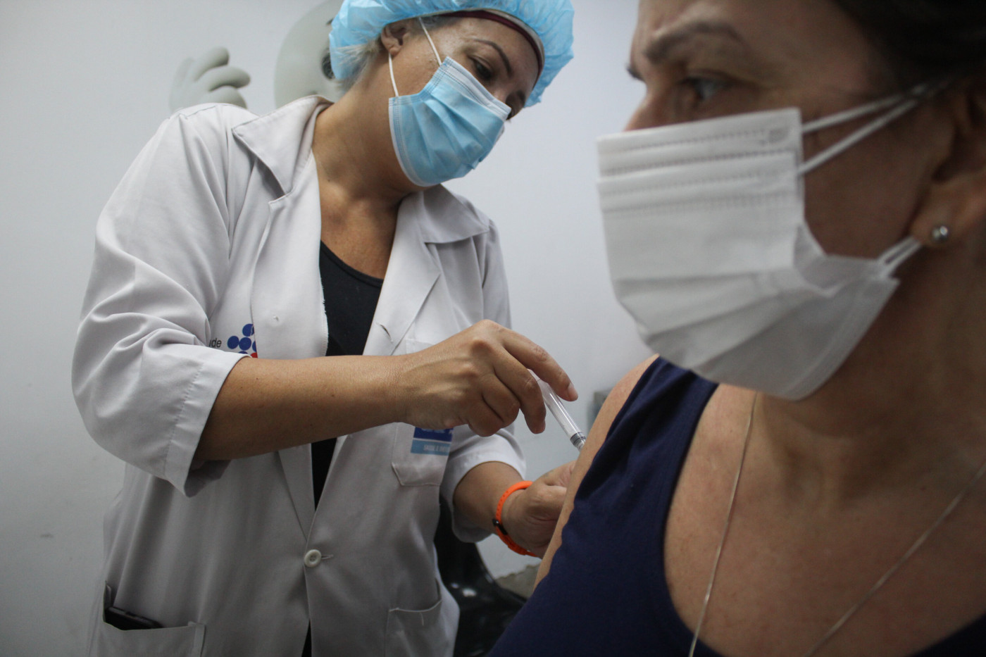 Enfermeira vacinando uma mulher contra a Covid-19