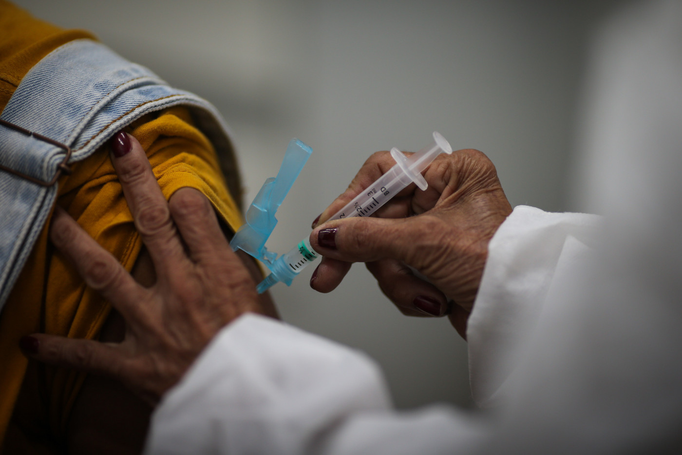 Profissional da saúde aplica vacina contra a Covid-19 no braço de uma pessoa