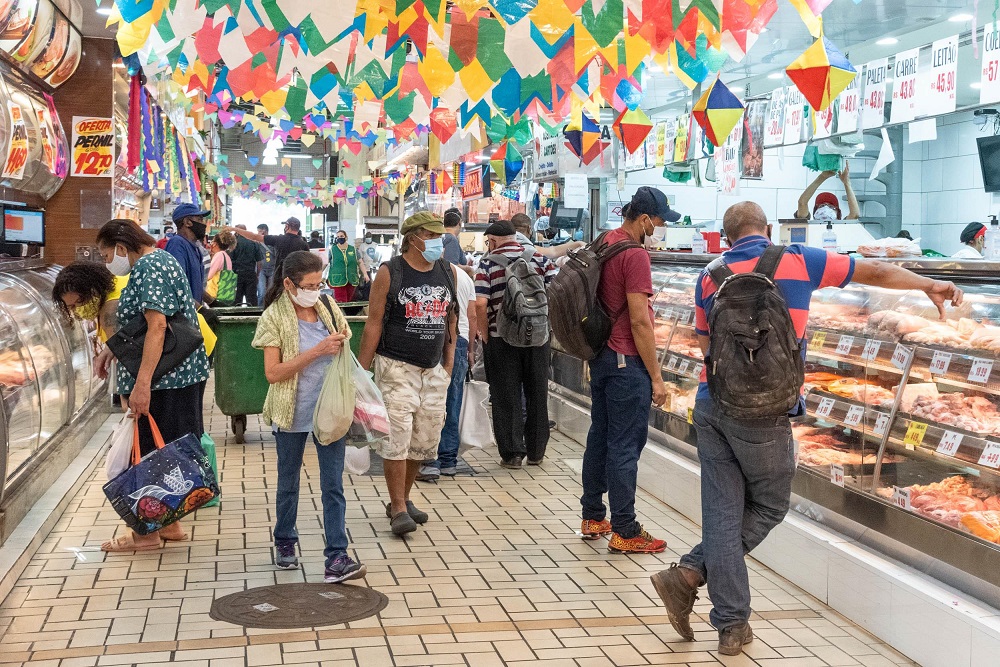 Clientes (pelo menos 18) se movimentam em corredor do Mercado Municipal da Lapa