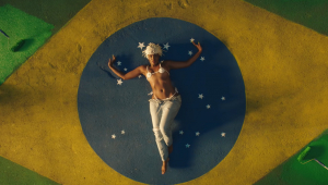 Iza aparece deitada sobre uma pintura da bandeira do Brasil em clipe de 'Gueto'