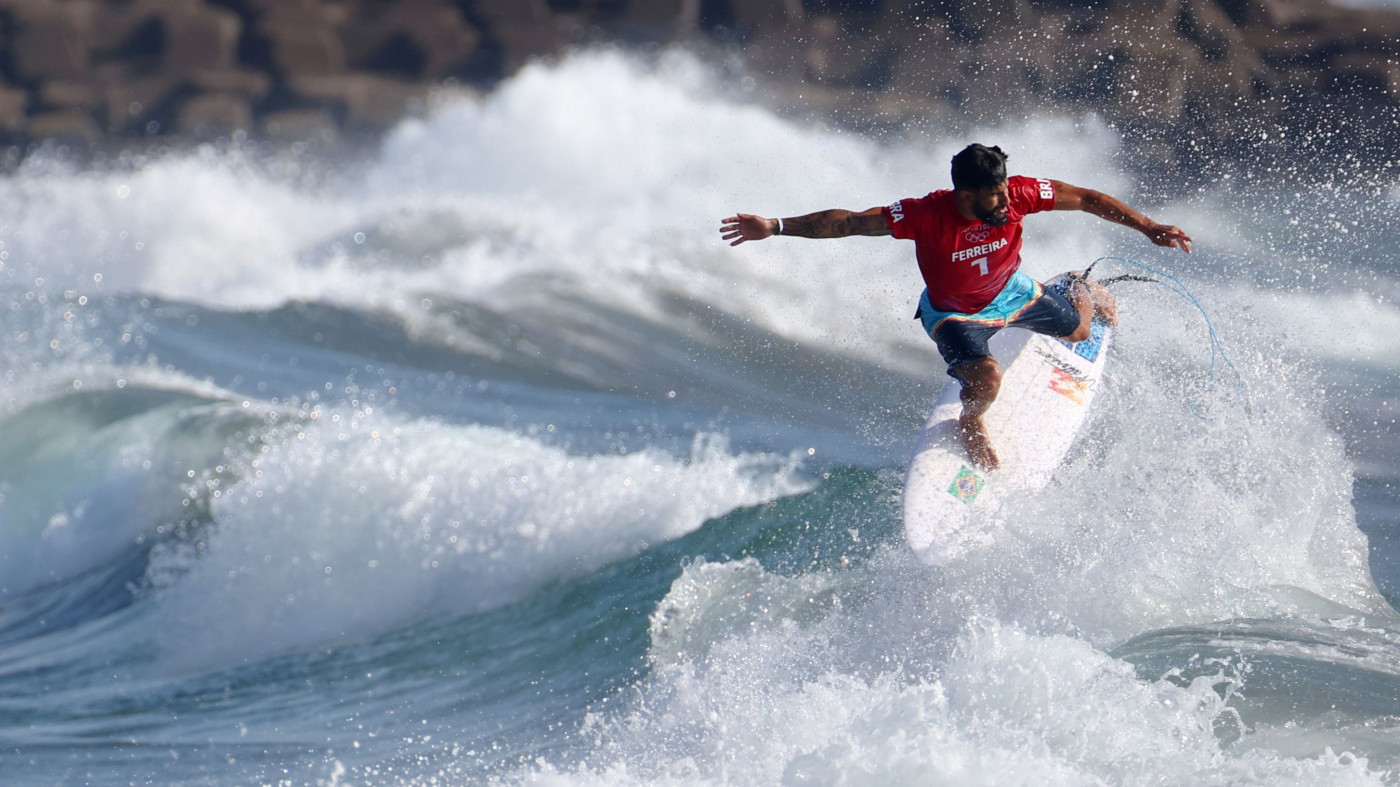 Surfista brasileiro fazendo manobra em Tóqui