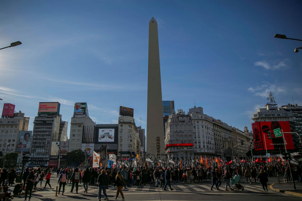 obelisco da argentina com pessoas ao redor protestando por empregos