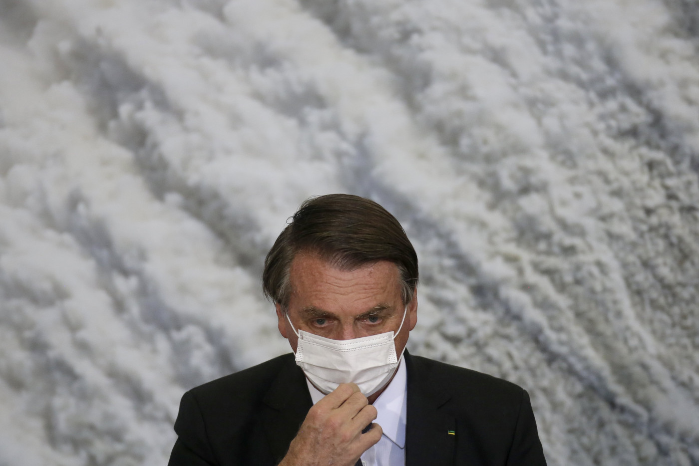 Jair Bolsonaro ajeita máscara de proteção branca