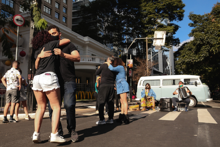 Pessoas dançam e se abraçam na Avenida Paulista