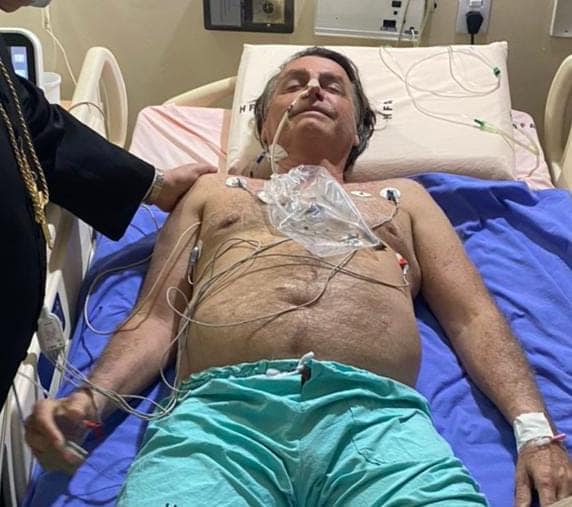Presidente Jair Bolsonaro em cama de hospital sem camisa deitado com vários acessos pelo corpo