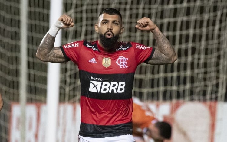 Gabigol com os braços para cima celebrando em campo