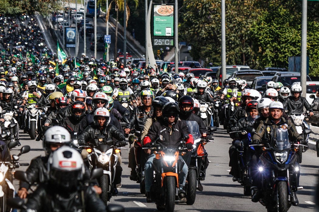 Várias pessoas de moto, incluindo o presidente Jair Bolsonaro, andando em rua de São Paulo