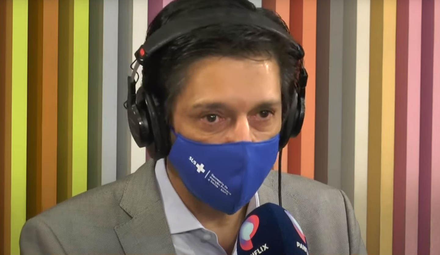 Ricardo Nunes de máscara azul falando no microfone no estúdio do Morning Show