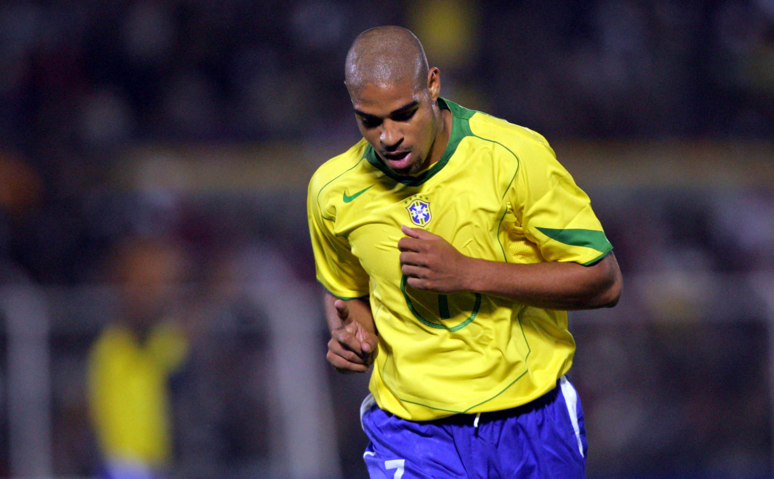 Homem com camiseta do brasil correndo em jogo de futebol