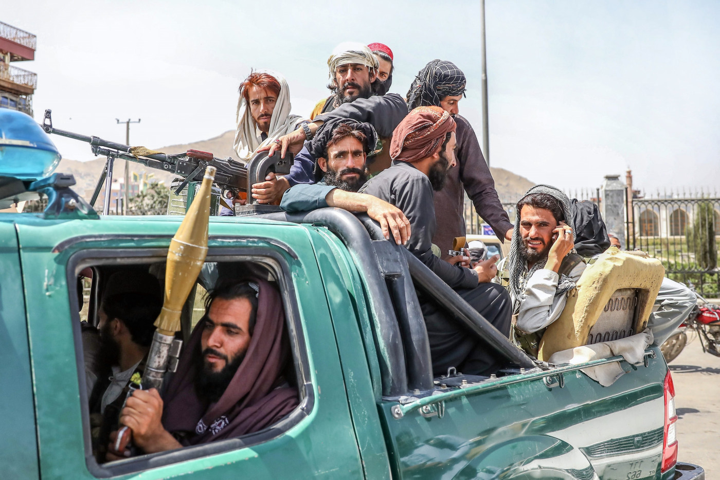 Combatentes talibãs são vistos na traseira de um veículo em Cabul,