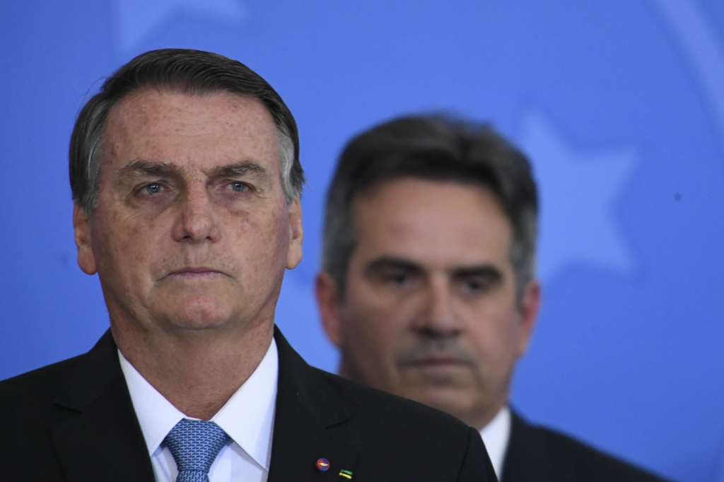 O presidente Jair Bolsonaro e o ministro Ciro Nogueira ao fundo
