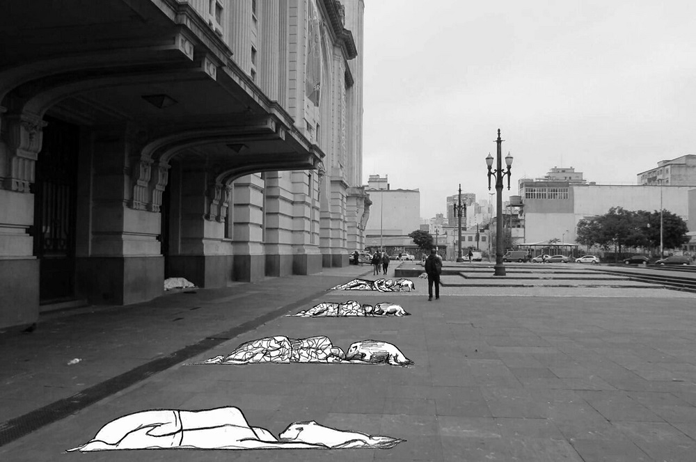 Imagem em preto e branco em um espaço público com desenhos que representam pessoas em situação de rua