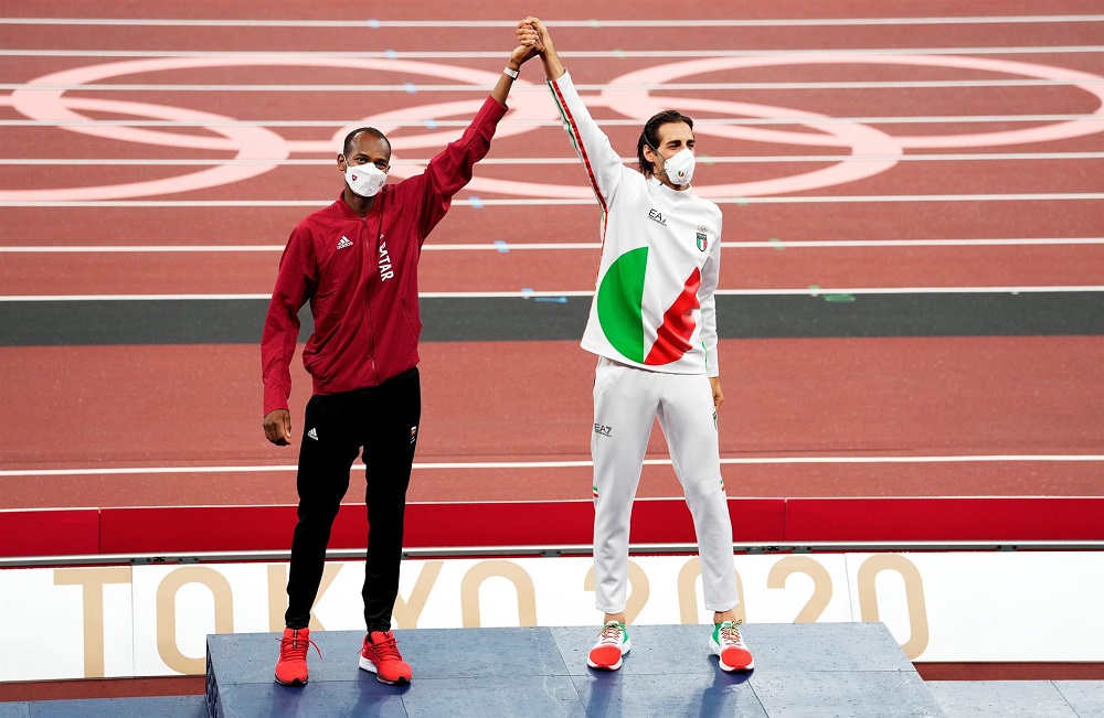 Com um dos braços erguidos e as mão dadas no alto, o catari Mutaz Essa Barshim (à esquerda da imagem) e o italiano Gianmarco Tamberi dividem o primeiro lugar no pódio