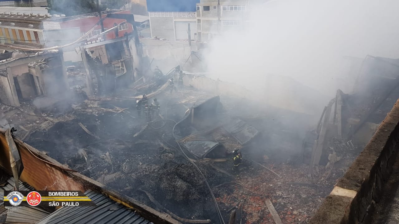 Destroços e fumaça branca saindo de um terreno após incêndio em Barueri