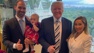 eduardo bolsonaro com filha no colo ao lado de Trump e da esposa