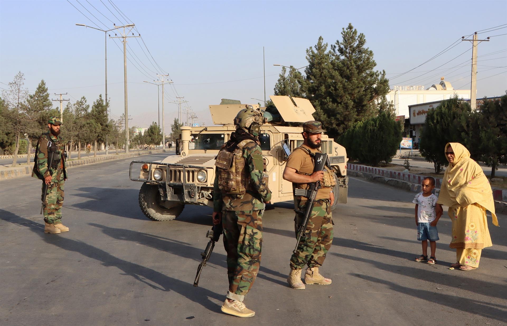 Homens em pé com armas e roupas militares