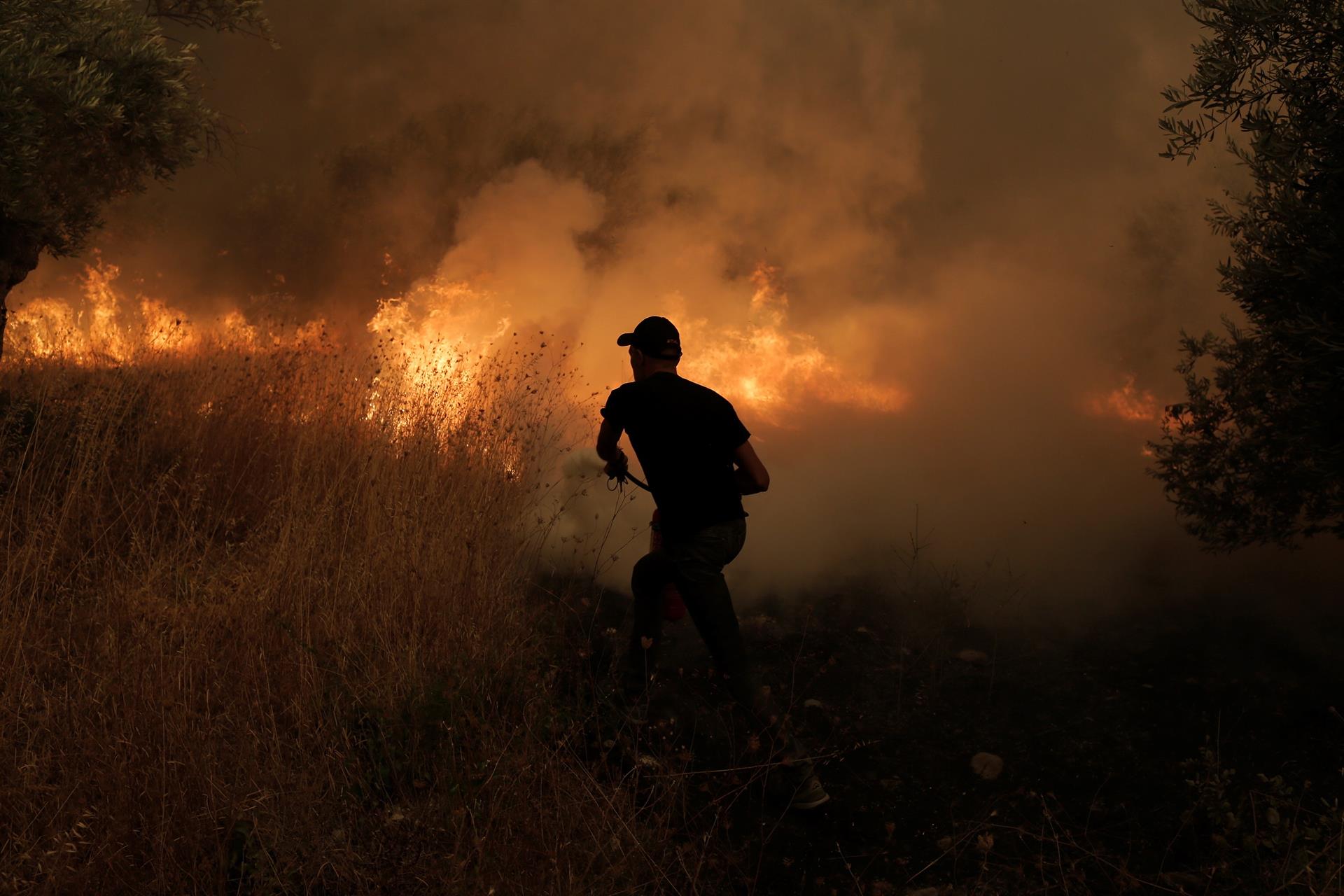 bombeiro tentando controlar incêndio na Grécia