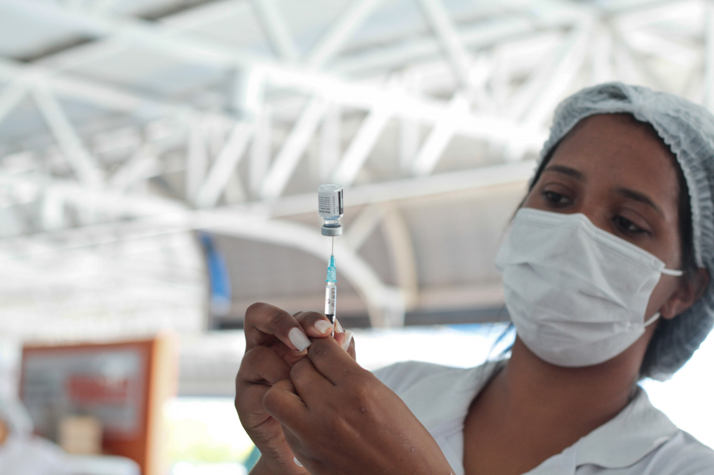 Na foto, enfermeira manipulando a vacina Pfizer durante aplicação em Salvador, Bahia