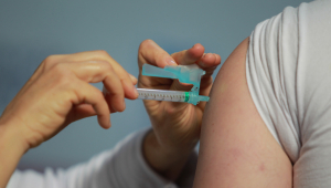 Profissional da saúde aplica vacina em pessoa