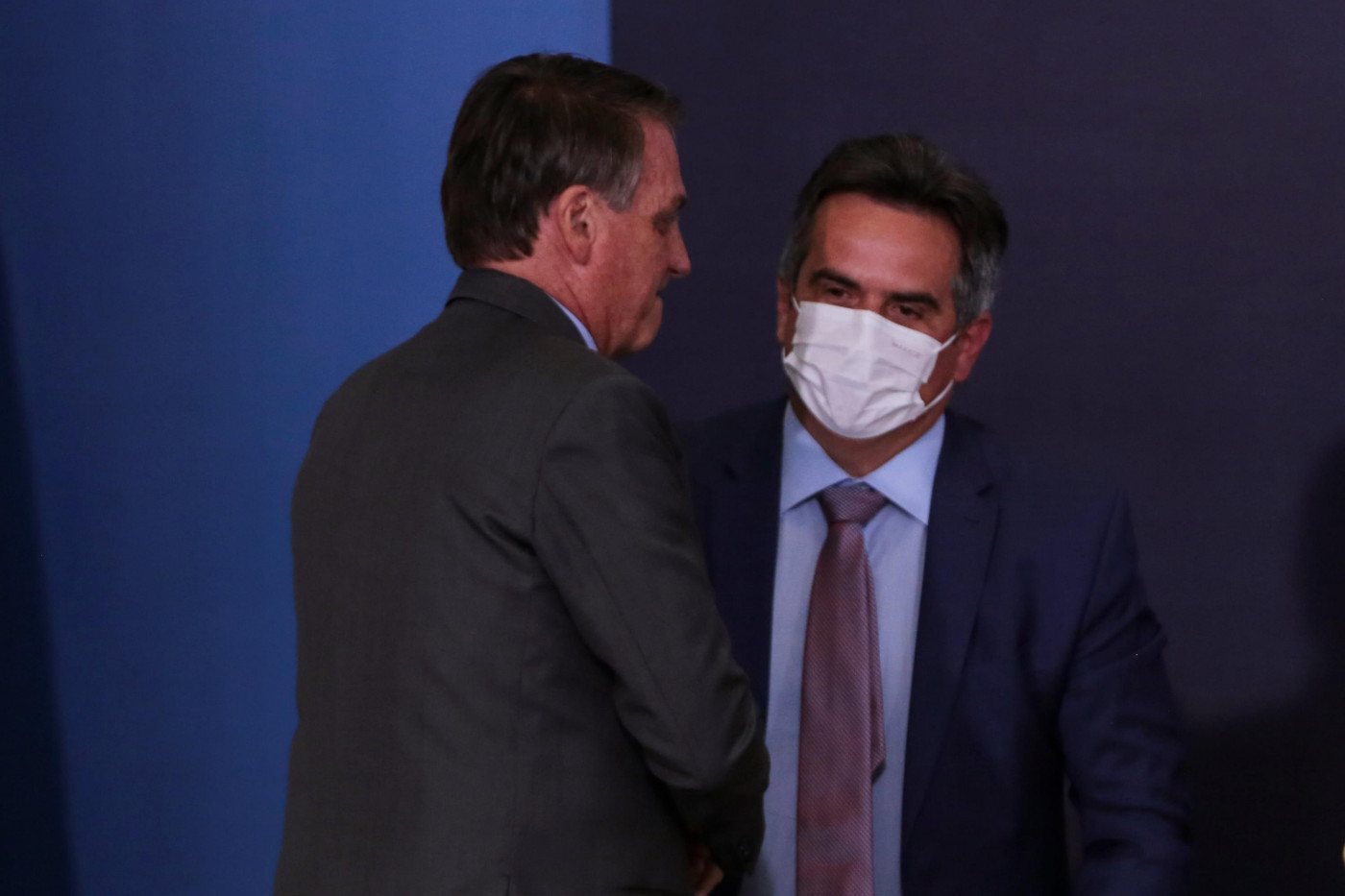 De costas, o presidente Jair Bolsonaro cumprimenta Ciro Nogueira, novo chefe da Casa Civil; ambos usam trajes sociais