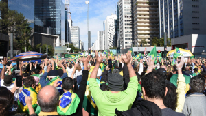 Pessoas seguram bandeiras e usam camisetas do Brasil em ato pró-bolsonaro