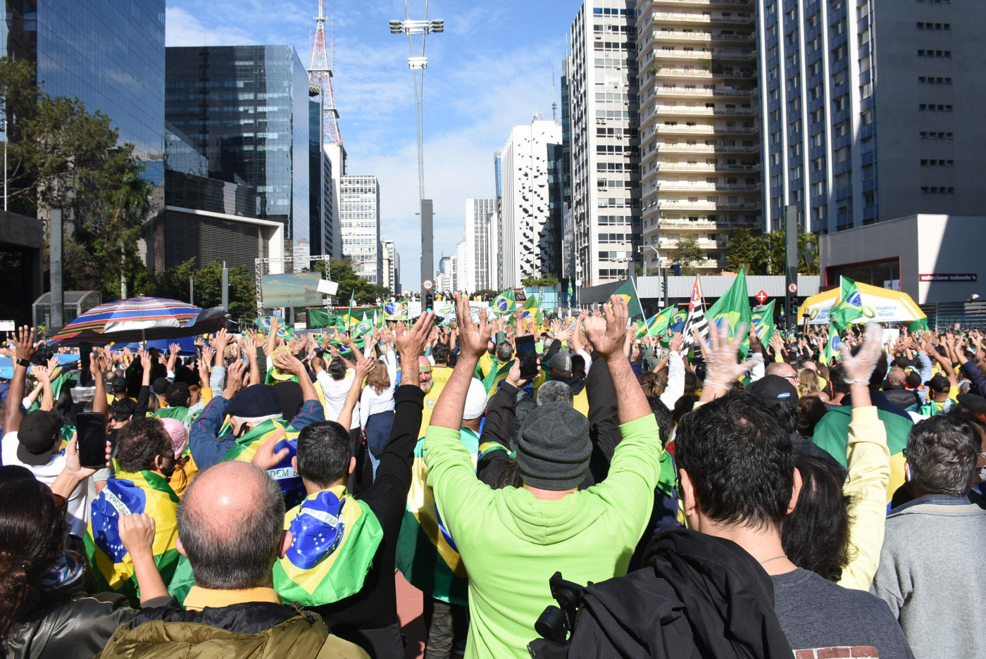Pessoas seguram bandeiras e usam camisetas do Brasil em ato pró-bolsonaro