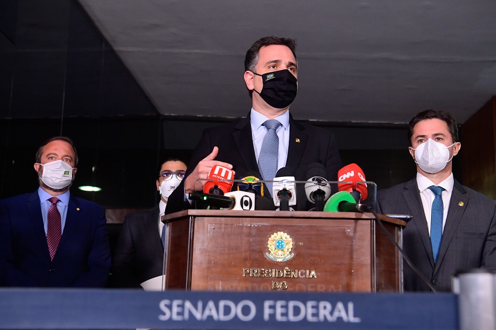 Com alguns microfones colocados em um púlpito, Rodrigo Pacheco dá entrevista no Senado Federal