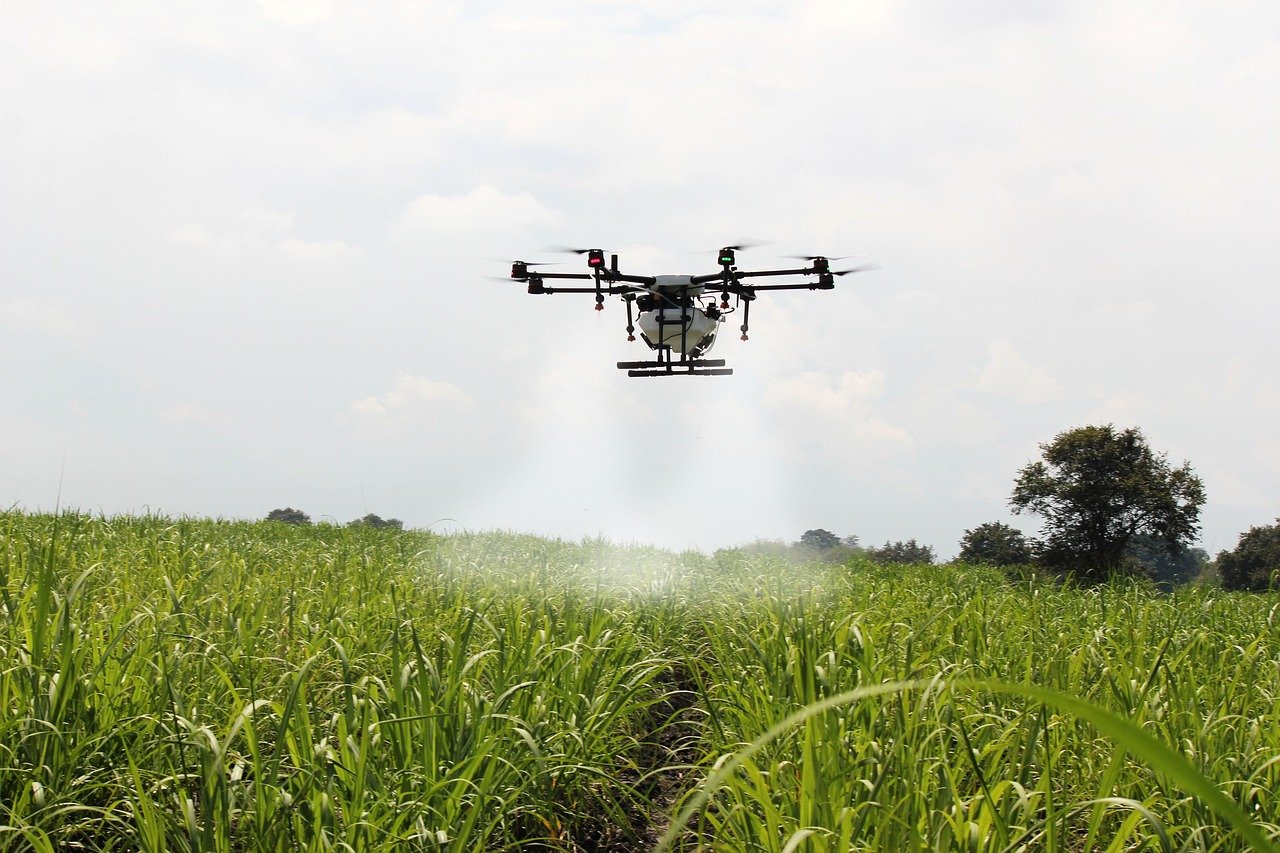 Espécie de drone jogando água sobre uma plantação verde