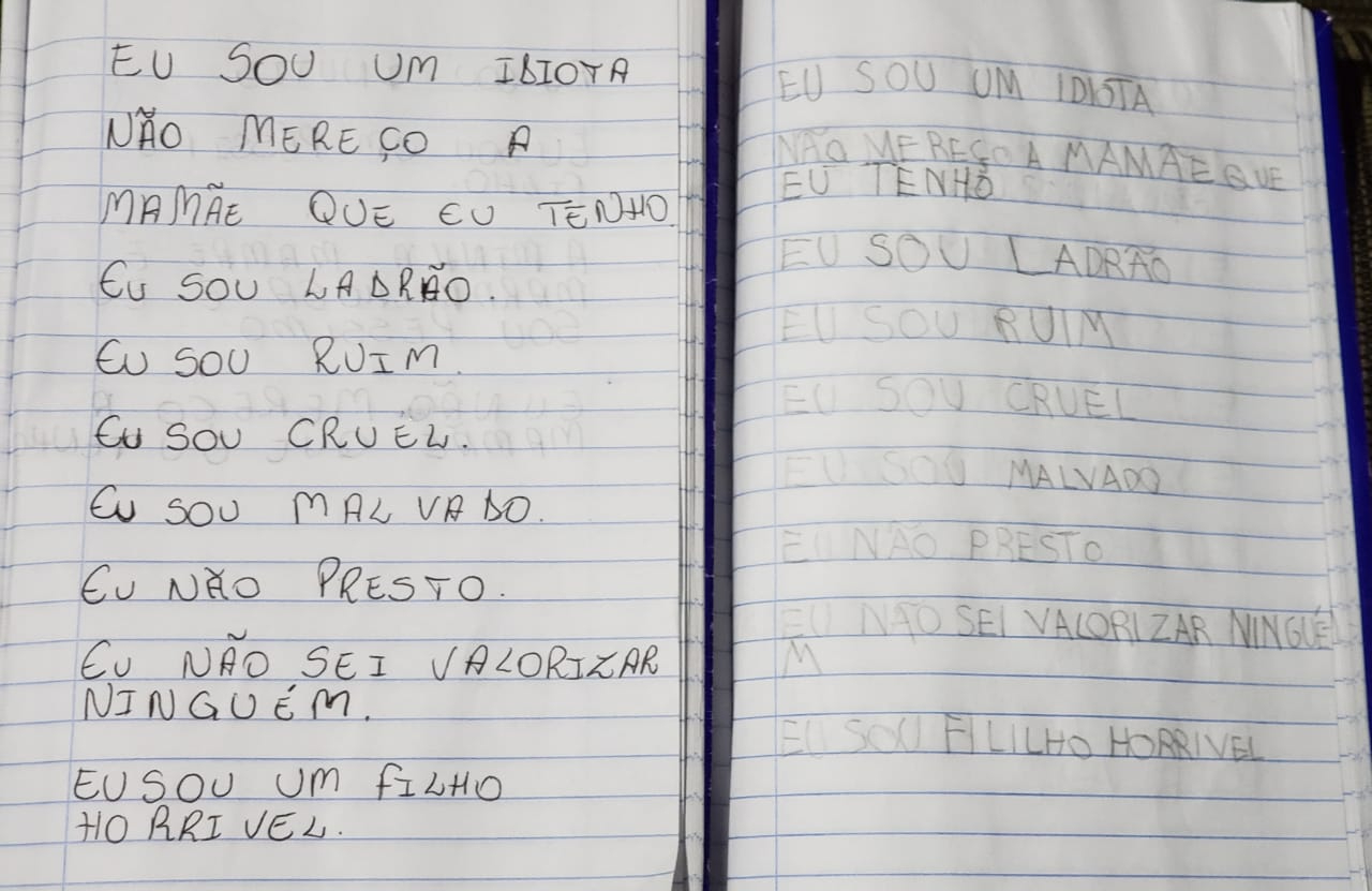 caderno com frases autodepreciativas escritas por menino