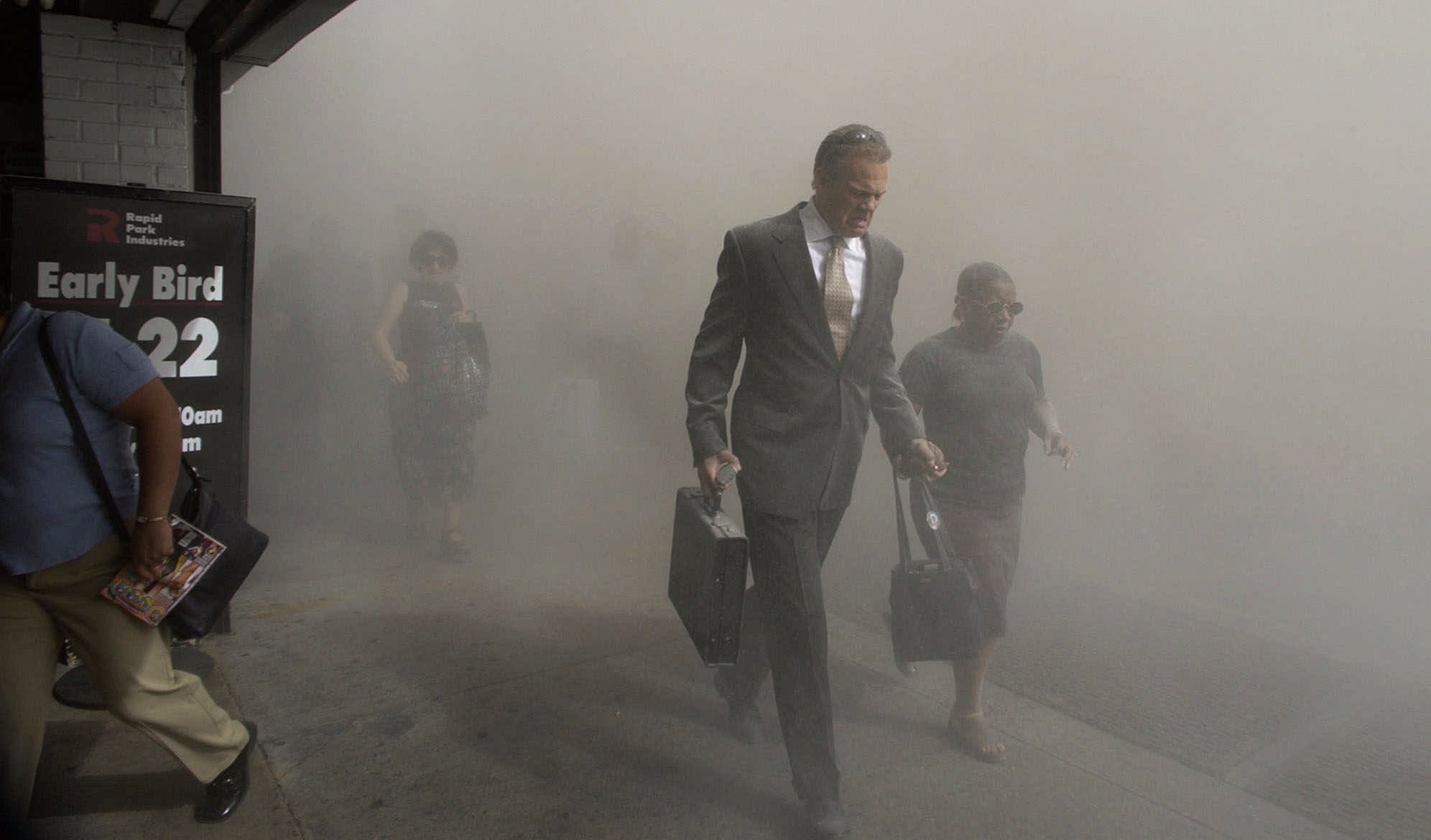 Pessoas cobertas com nuvem de fumaça após desabamento da torre sul do World Trade Center