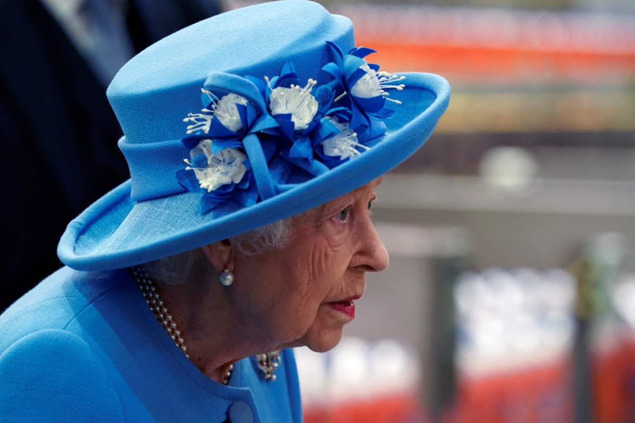 Rainha Elizabeth de perfil usando chapéu e roupa azul