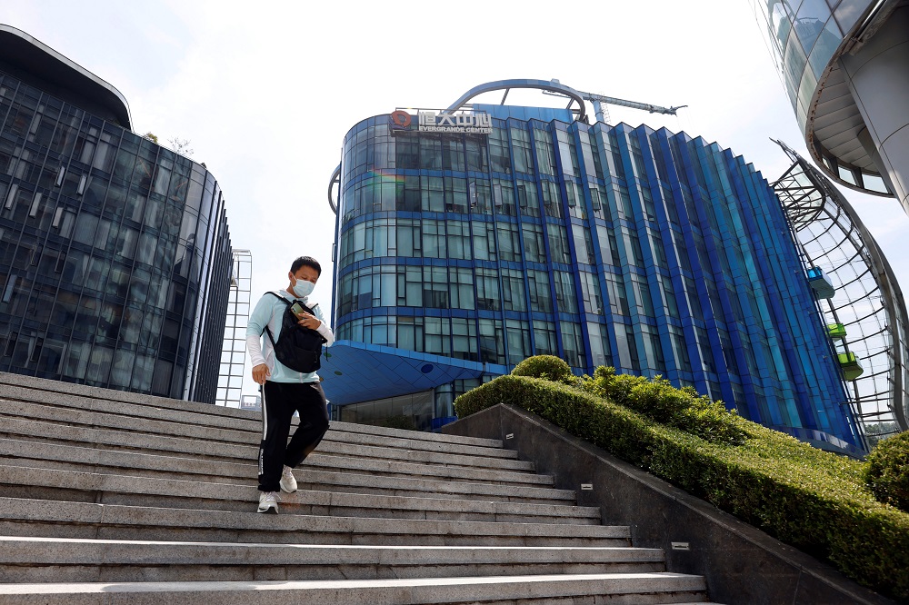 Homem desce uma escada em frente a um prédio comercial na China