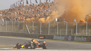 Torcida holandesa faz festa na arquibancada lotada, com direito a fumaça laranja, enquanto Max Verstappen corre na pista com sua Red Bull