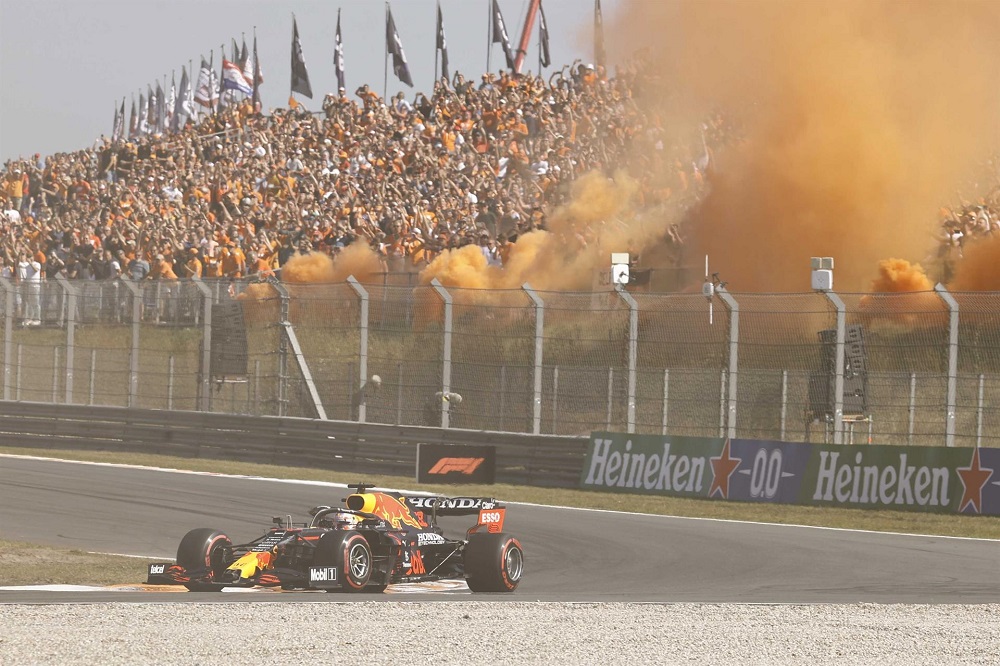 Torcida holandesa faz festa na arquibancada lotada, com direito a fumaça laranja, enquanto Max Verstappen corre na pista com sua Red Bull