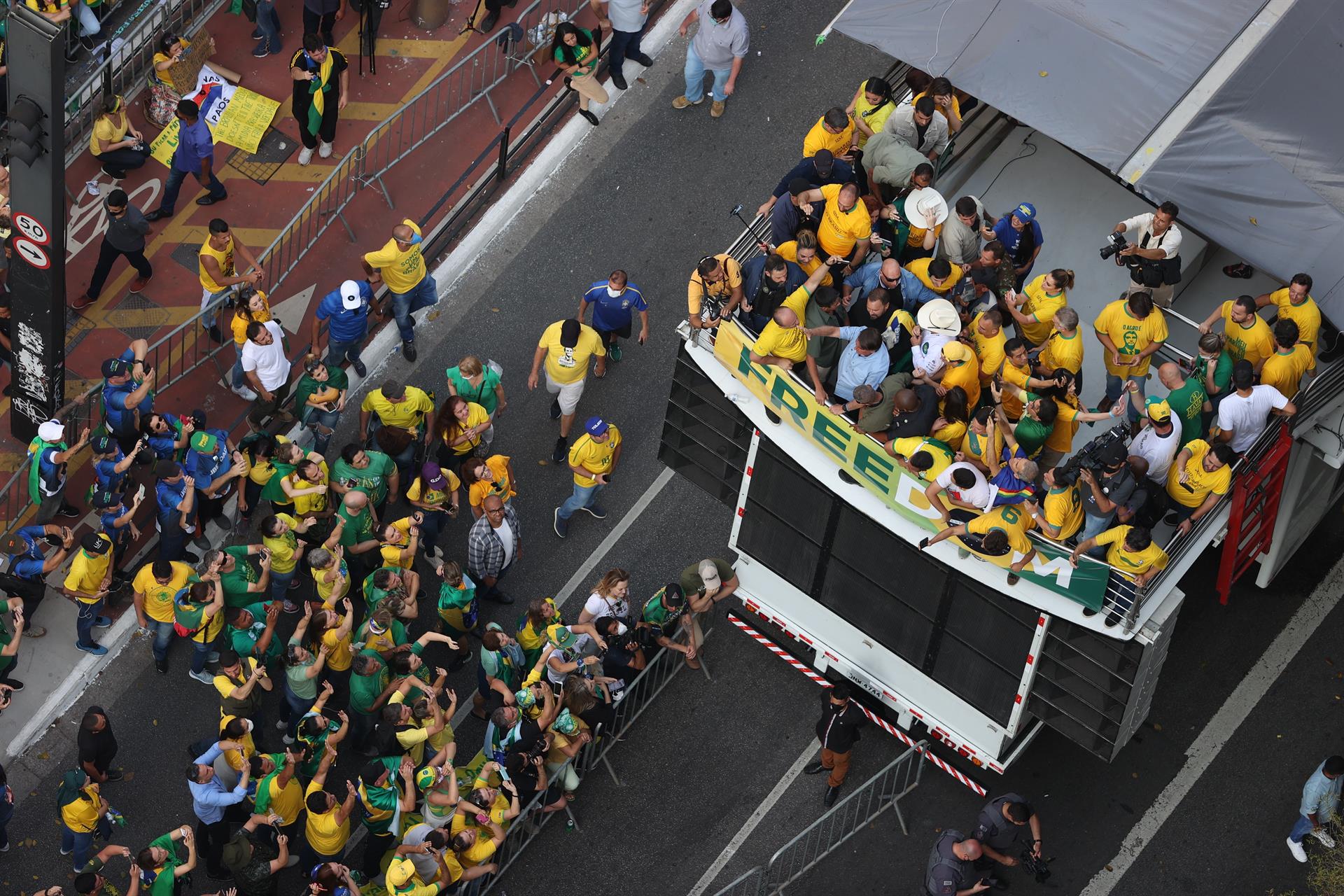 O presidente Jair Bolsonaro (camisa azul claro) em carro de som na avenida Paulista