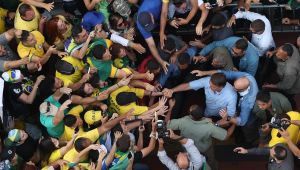 O presidente Jair Bolsonaro (camisa azul claro) acena para apoiadores em ato na avenida Paulista