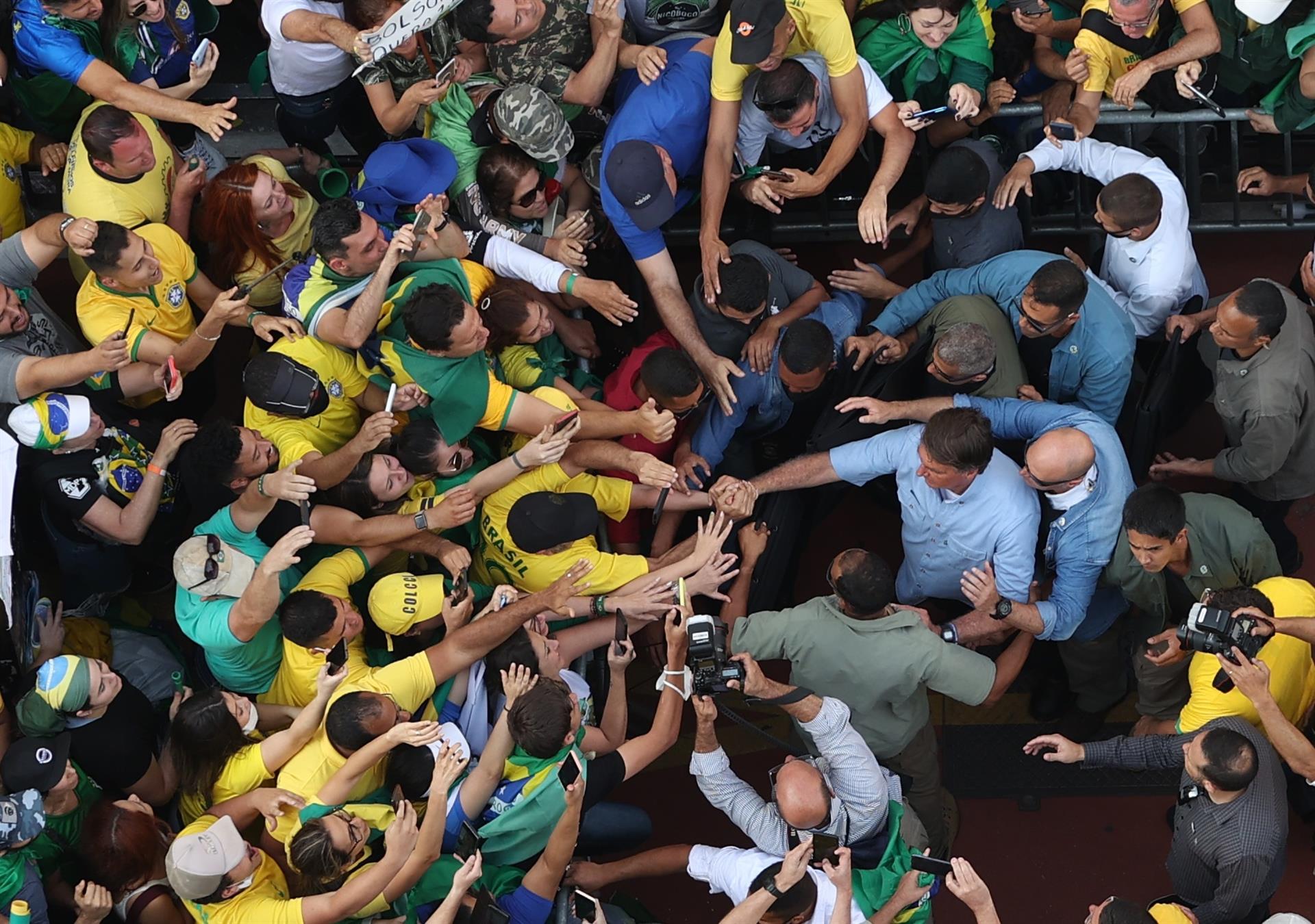 O presidente Jair Bolsonaro (camisa azul claro) acena para apoiadores em ato na avenida Paulista