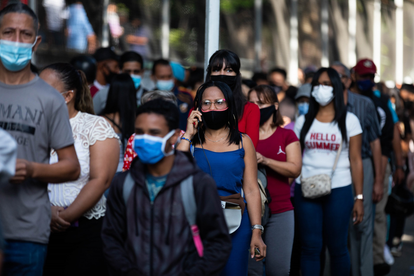 Pessoas usam máscara de proteção em fila da vacinação