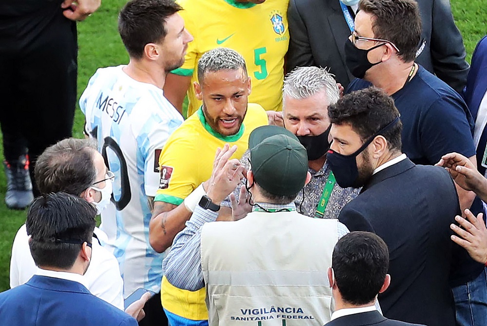 Os jogadores Neymar e Lionel Messi conversam com agentes da Anvisa e da Polícia Federal que invadiram o campo da Neo Química Arena
