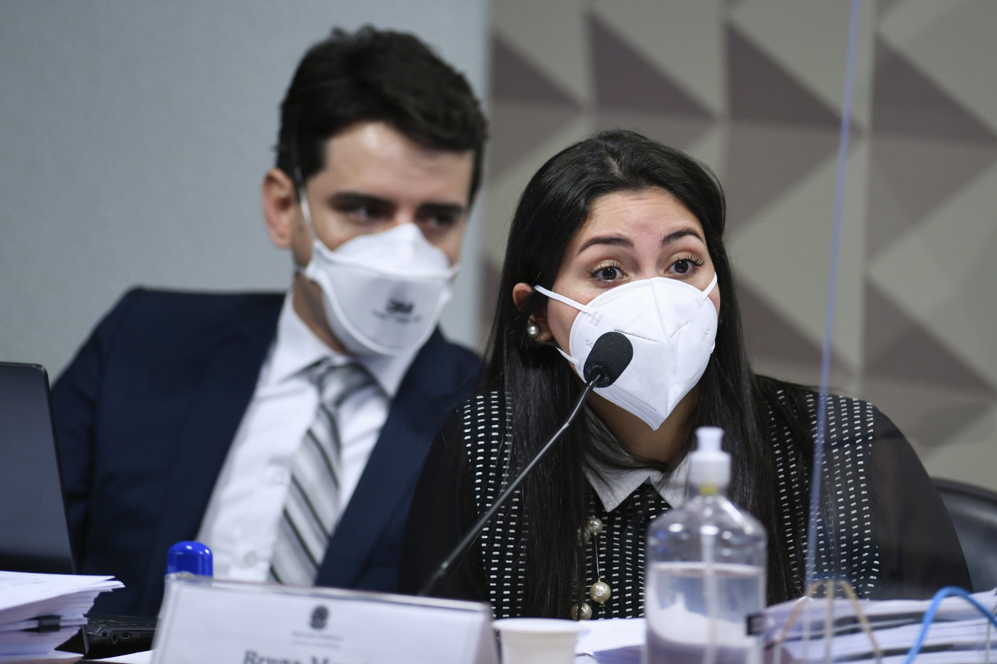 Mulher de máscara acompanhada de advogado