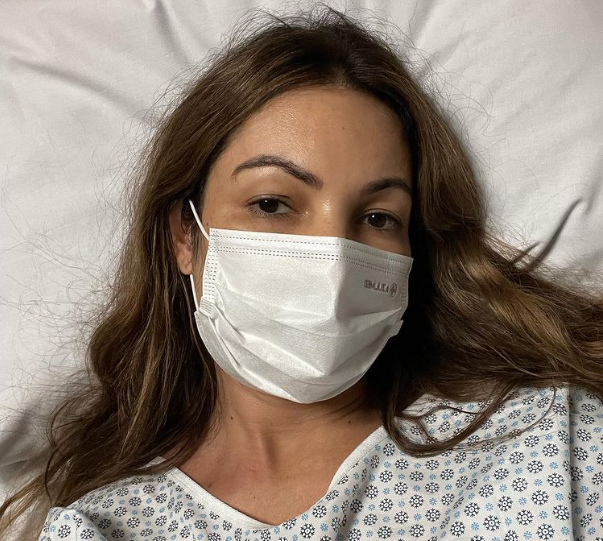 Patrícia Poeta usa máscara e está deitada numa cama de hospital