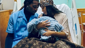 Cardi B e Offset seguram bebê no colo em maca de hospital, cobertos por manta da Louis Vuitton
