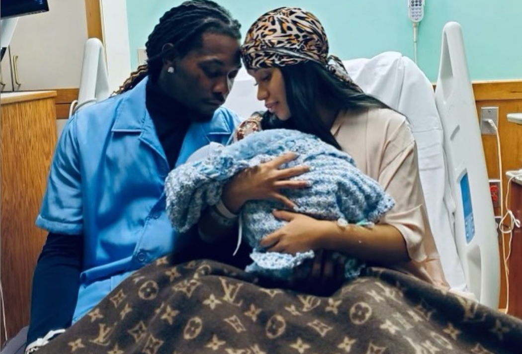 Cardi B e Offset seguram bebê no colo em maca de hospital, cobertos por manta da Louis Vuitton