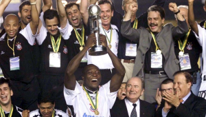 Cercado por jogadores, dirigentes e membros da comissão técnica do Corinthians, Rincón levanta o troféu do Mundial de 2000